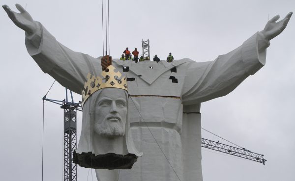 Workers raise the crowned head of a statue of Jesus before placing it slowly onto the figure's body, in Swiebodzin, Poland, on Saturday Nov. 6, 2010. Workers have completed a giant statue of Jesus Christ in a small Polish town that its creators say ranks as the biggest in the world. . (AP Photo/Czarek Sokolowski)